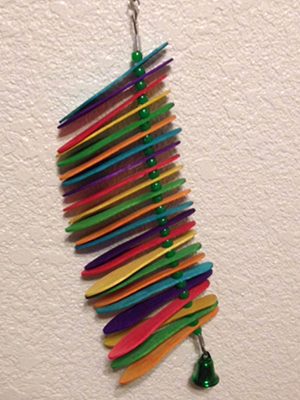 A colorful bird toy hanging on a wall.